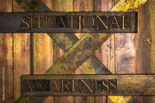 Photo of real authentic typeset letters Situational Awareness text on vintage textured grunge copper and gold background