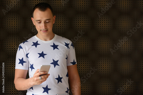 Portrait of handsome man using phone against abstract background