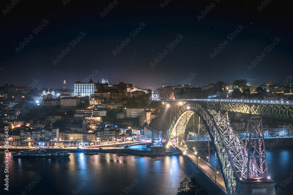 Panoramic landscape view on the old town with Douro river and the bridge in Porto city at night in Portugal