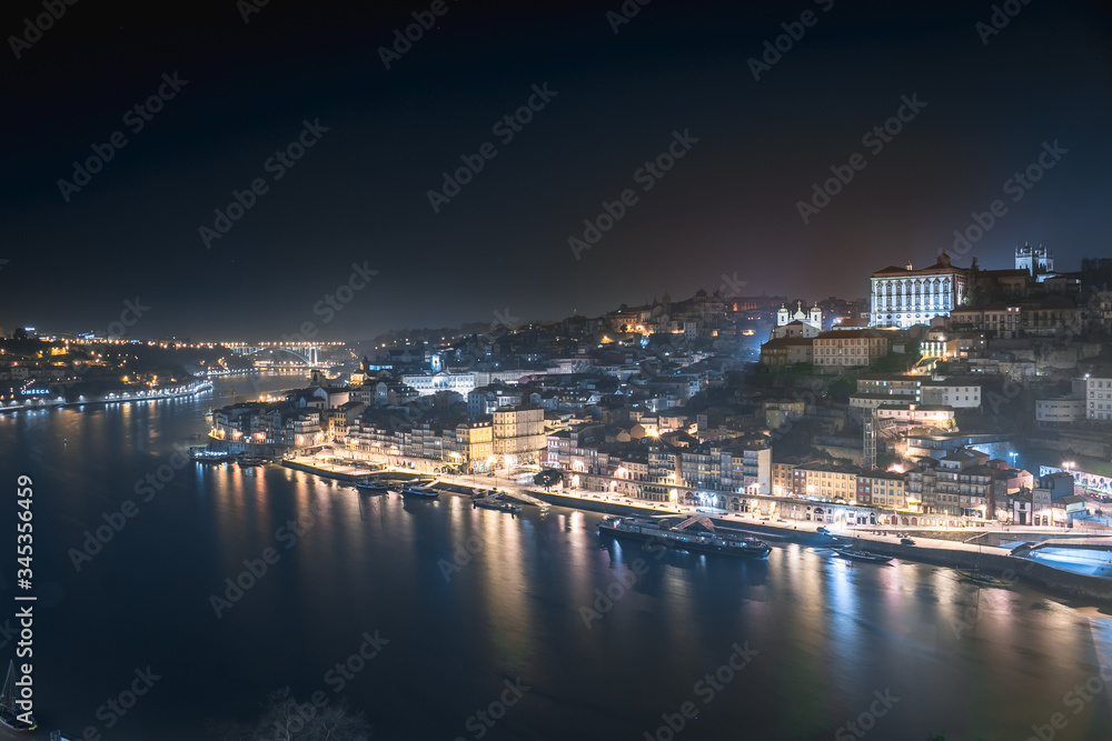 Panoramic landscape view on the old town with Douro river in Porto city at night in Portugal