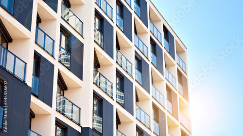 Modern apartment buildings on a sunny day with a blue sky. Facade of a modern apartment building. Glass surface with sunlight.