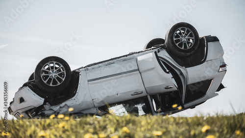 Fotografie Horrific Traffic Accident, Rollover Smoking and Burning Vehicle Lying on its Roof in the Middle of the Road after Collision