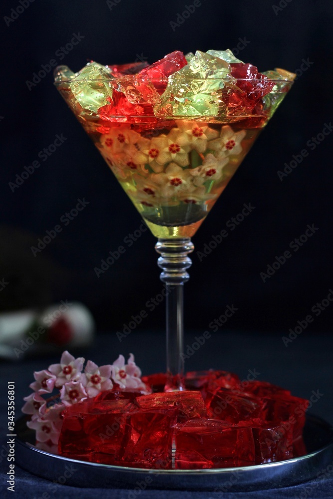 Sweet jelly dessert, design food, creative meals with vanilla flowers in dark mood on black background