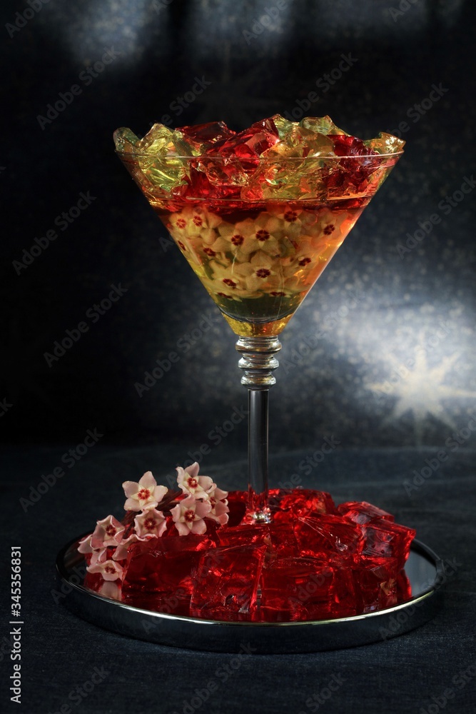 Sweet jelly dessert, design food, creative meals with vanilla flowers in dark mood on black background