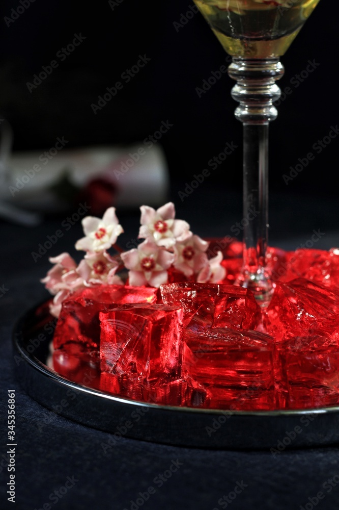 Sweet jelly dessert, design food, creative meals with vanilla flowers in dark mood on black background