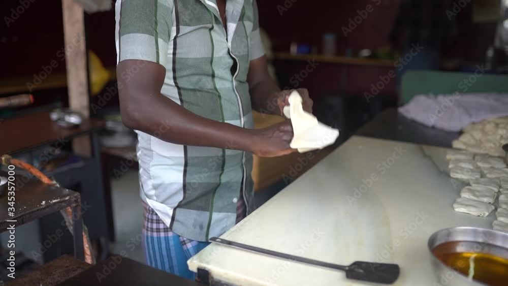 Plano detalle de las manos de un hombre haciendo paratha (comida india). Imágenes del 25/11/2019 en Kochi, Kerala (India)