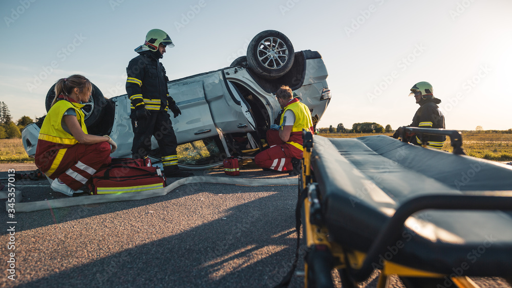 On the Car Crash Traffic Accident Scene: Paramedics and Firefighters Rescue  Injured Victim Trapped in the Vehicle. Extricate Person Using Stretchers,  Give First Aid and Transport Them to Hospital Photos | Adobe