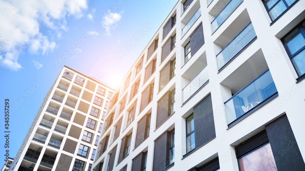 Modern apartment buildings on a sunny day with a blue sky. Facade of a modern apartment building. Glass surface with sunlight. Modern apartment buildings on a sunny day with a blue sky. Facade of a modern apartment building. Glass surface with sunlight.
