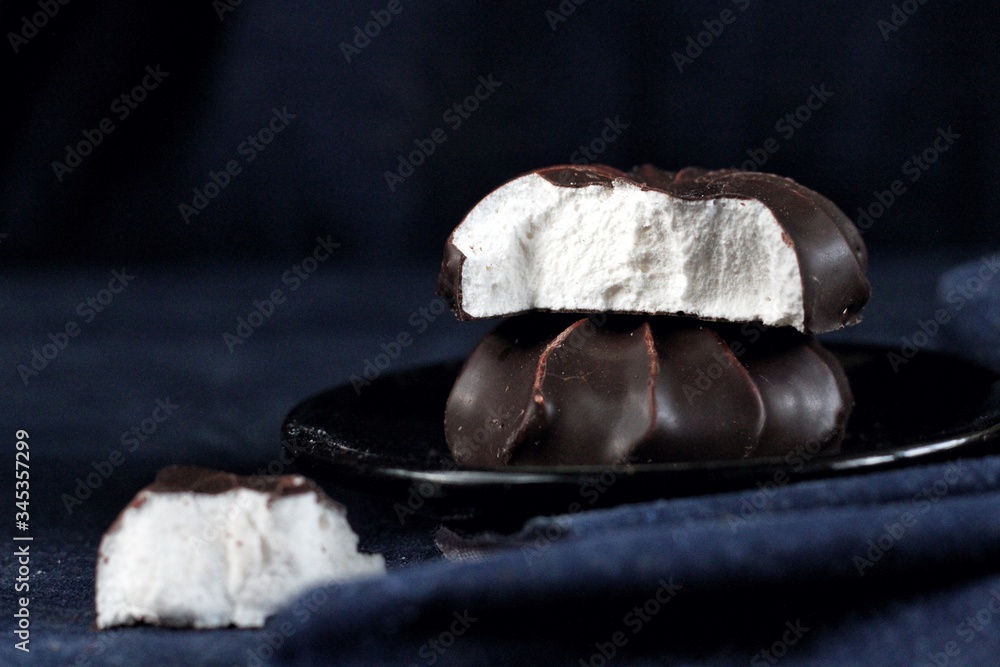 Close up of chocolate marshmallows, design food, dark mood on black background