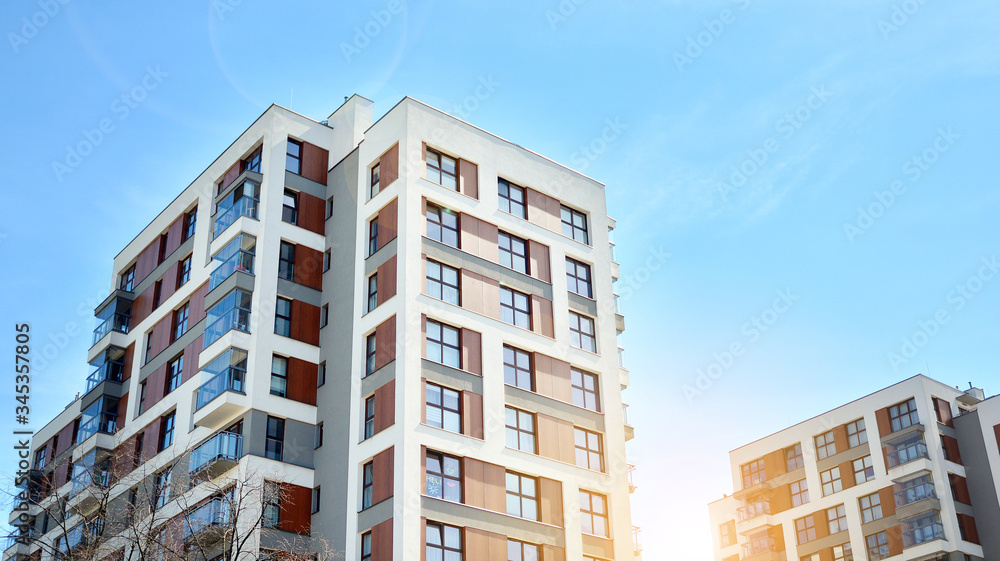 Modern apartment buildings on a sunny day with a blue sky. Facade of a modern apartment building. Glass surface with sunlight.