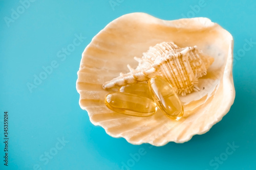 Omega 3 capsules on shell, sea salt and fish oil pills. © SValeriia