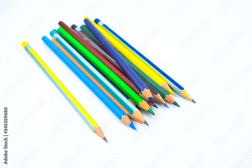 Stack of different colored wood pencil crayons placed on a white background