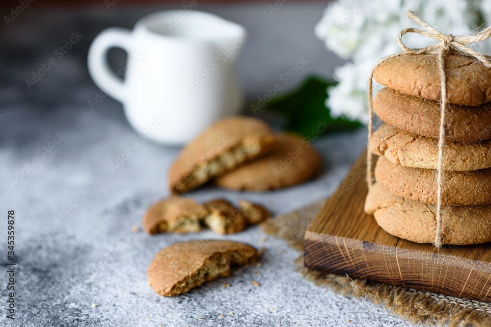 Homemade oatmeal cookies on a wooden cutting board on old table background Homemade oatmeal cookies on a wooden cutting board on old table background