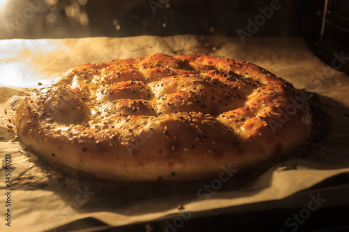 Homemade Ramadan Pita (Ramazan Pidesi) is cooking in oven. Traditional Turkish bread for month Ramadan.  photo