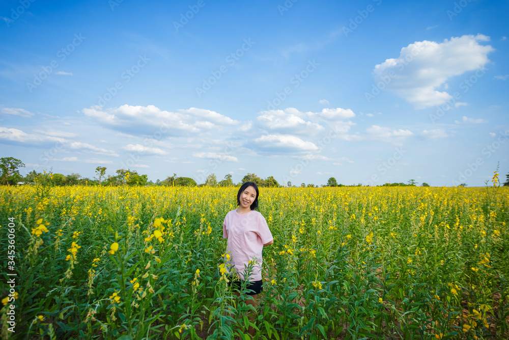 back view of young woman standing in hemp flowers field. back view of young woman standing in hemp flowers field.