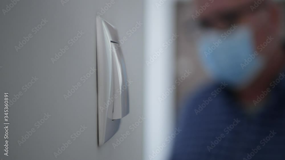 Man Wearing protection Mask and Gloves Turning Off the Light from the Switch on the Wall and Leaving the Office Room Man Wearing protection Mask and Gloves Turning Off the Light from the Switch on the Wall and Leaving the Office Room