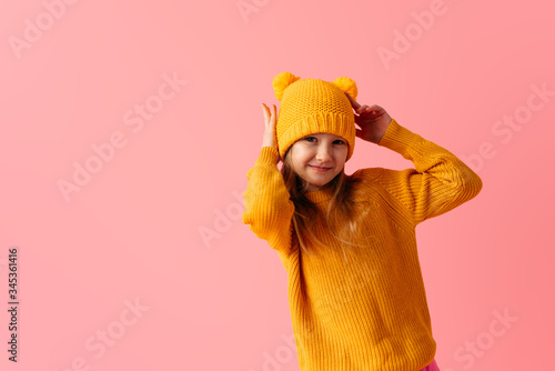 Smilng little girl wearing nice yellow hat and sweater