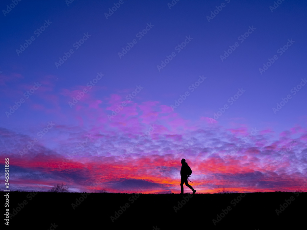 Man playing sports on the mountain with sunset and sea.