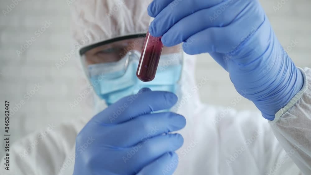 Slow Motion with a Doctor Wearing a Protection Suit Analyze a Blood Test with Coronavirus Infection in Hospital Laboratory Slow Motion with a Doctor Wearing a Protection Suit Analyze a Blood Test with Coronavirus Infection in Hospital Laboratory