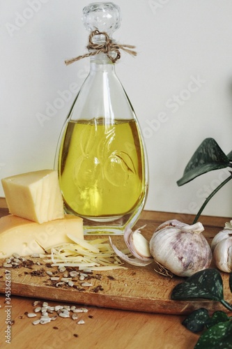Obraz na płótnie Art composition, design food - oil, garlic, spices and cheese on wooden table and white background w salonie
