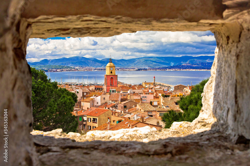Saint Tropez village church tower and old rooftops view through stone window photo