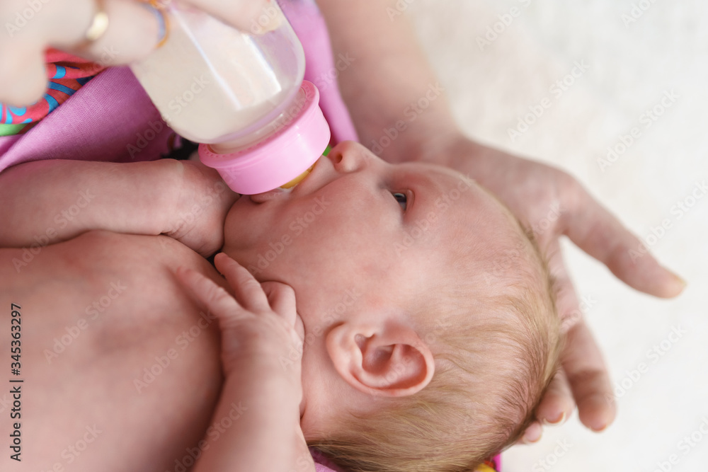 he lure of artificial food. A newborn baby is fed from a bottle. My mothers hand gently supports the head he lure of artificial food. A newborn baby is fed from a bottle. My mothers hand gently supports the head