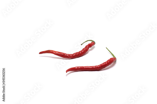 Two curly red chillies (Capisicum annuum) low angle isolated on white background