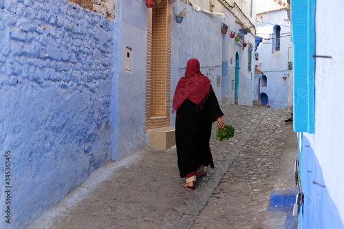 Local woman in black cloak in the city of  Chefchaouen,Morocco. © leospek