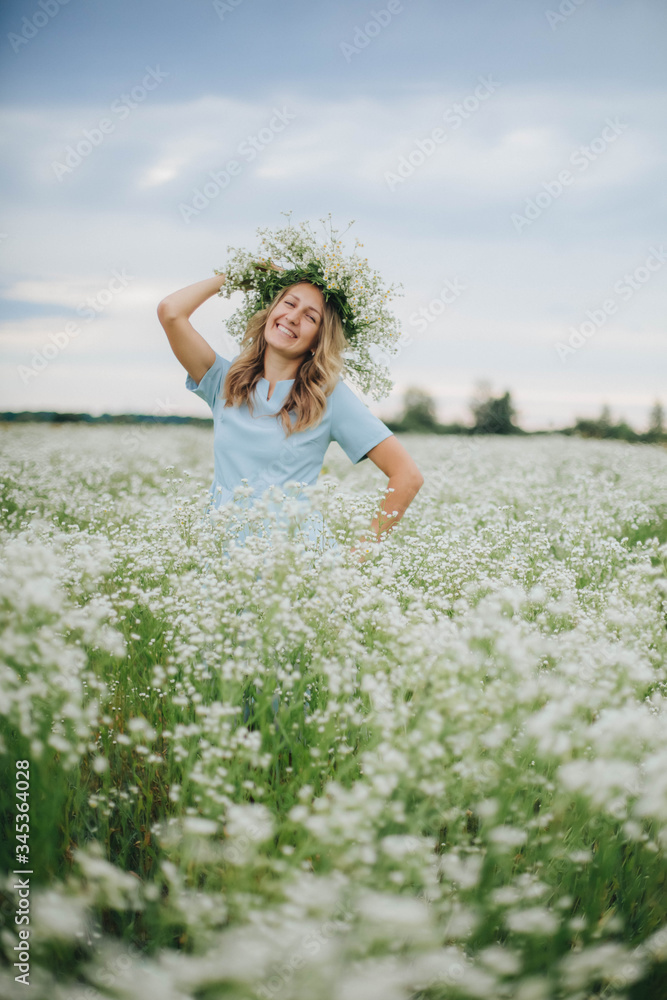 beautiful blonde girl in a field of daisies. wreath of wildflowers on his head. woman in a blue dress in a field of white flowers. charming girl with a bouquet of daisies. summer tender photo beautiful blonde girl in a field of daisies. wreath of wildflowers on his head. woman in a blue dress in a field of white flowers. charming girl with a bouquet of daisies. summer tender photo