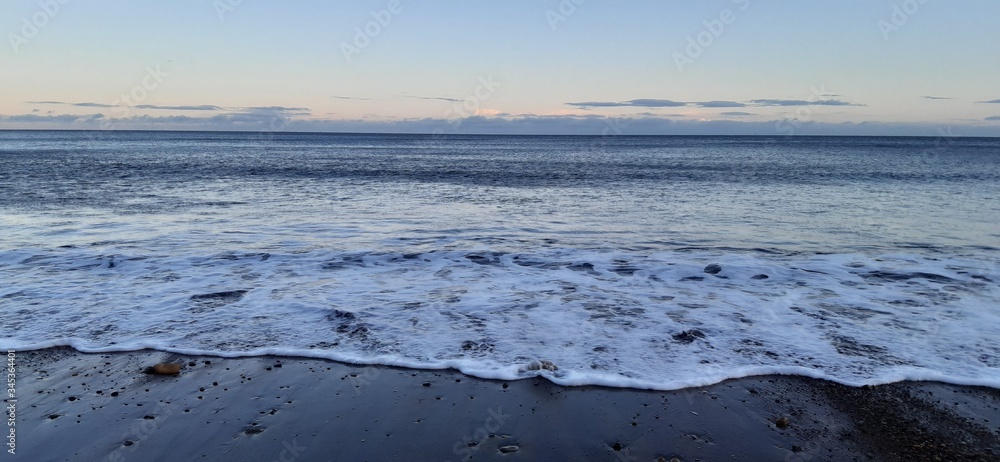 Sandy beach view with waves at sunset in Whitby, North Yorkshire Sandy beach view with waves at sunset in Whitby, North Yorkshire