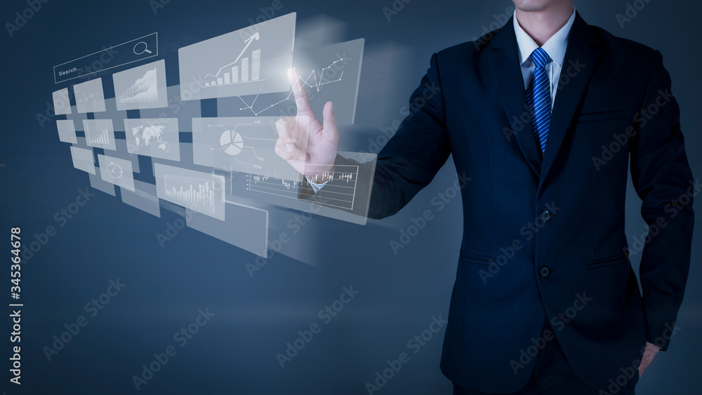 Business man is touching on virtual screen , grey background in studio Business man is touching on virtual screen , grey background in studio