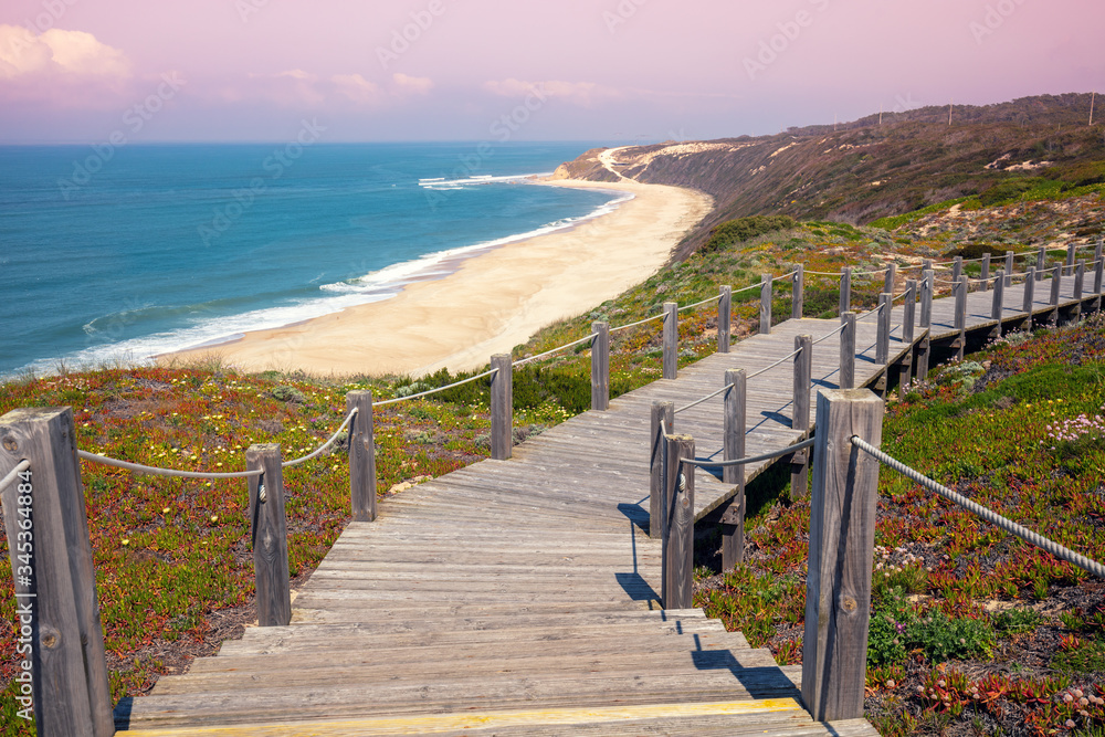 Paredes Panoramic Boardwalk. The wooden stairway on the rocky seashore on a sunny day. Polvoeira the beach, Portugal