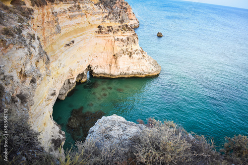 Viewpoint of the natural arches, orange cliffs and turquoise waters, at sunset. Concept of tourism and travel. Algarve, Portugal