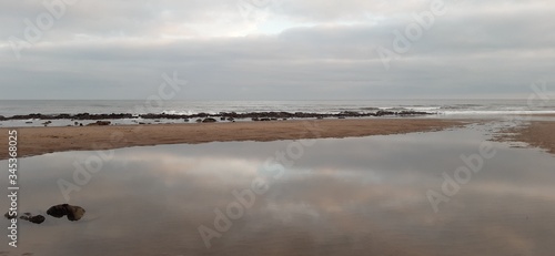View over Whitby beach with rocks  reflections and pools