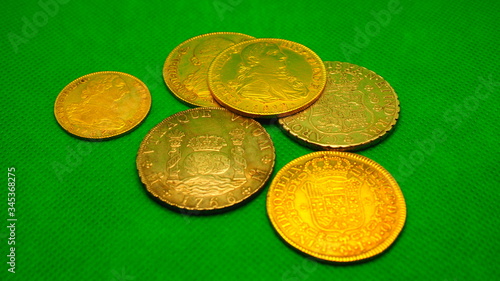 Silver and Gold Spanish ancient coins on green background. photo