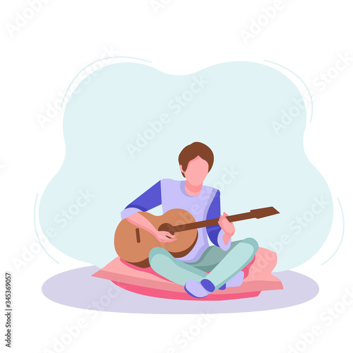 Young guy plays the guitar, musician, teenager free time, spends time on the pillow, sitting in the living room,