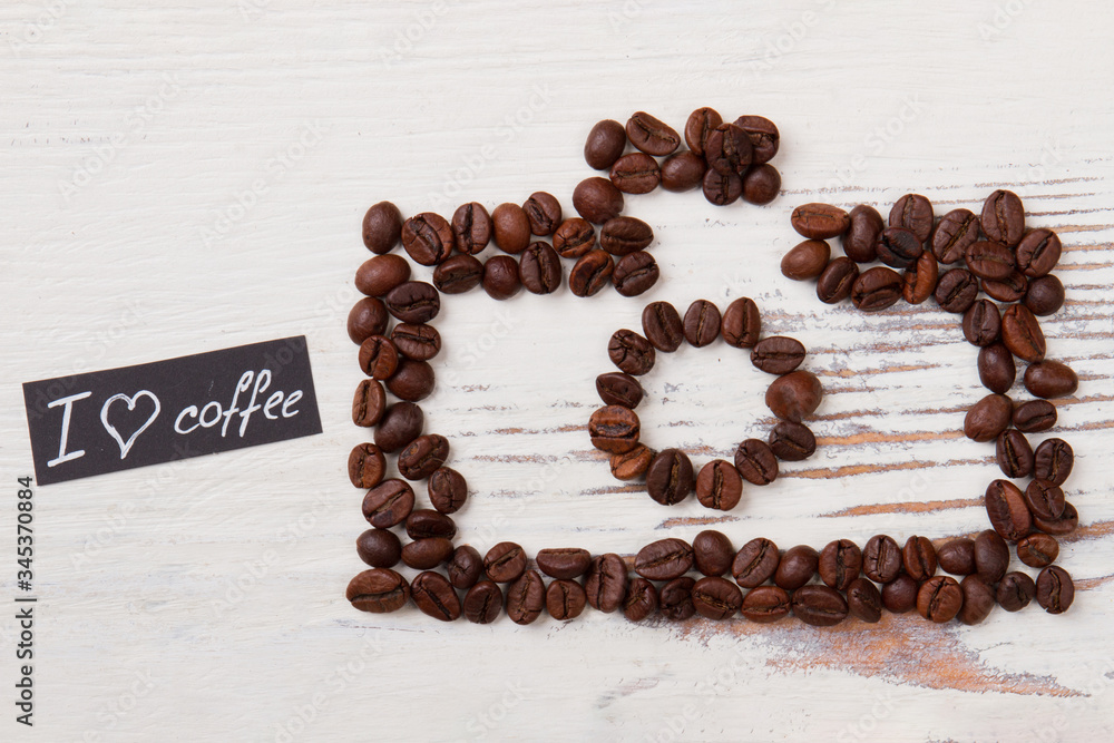 Roasted coffee beans in a shape of photo camera. Love for coffee concept. White wood background. Roasted coffee beans in a shape of photo camera. Love for coffee concept. White wood background.