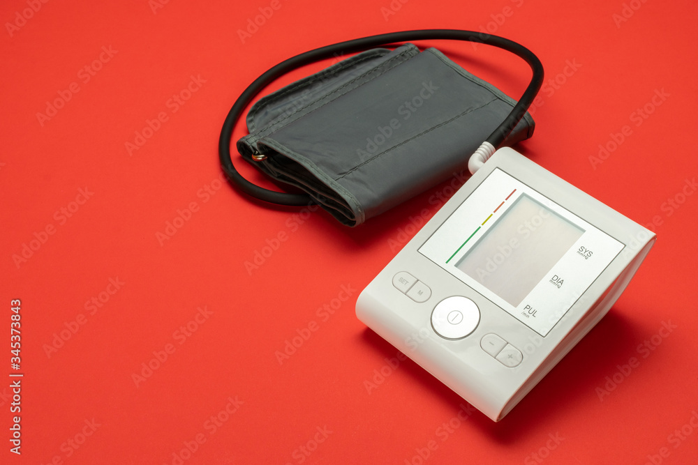 Pressure meter. Patient test hypertension from medical sphygmomanometer. Health monitor for check doctor blood pressure isolated on red background. Hospital diagnostic technology. Pressure meter. Patient test hypertension from medical sphygmomanometer. Health monitor for check doctor blood pressure isolated on red background. Hospital diagnostic technology.