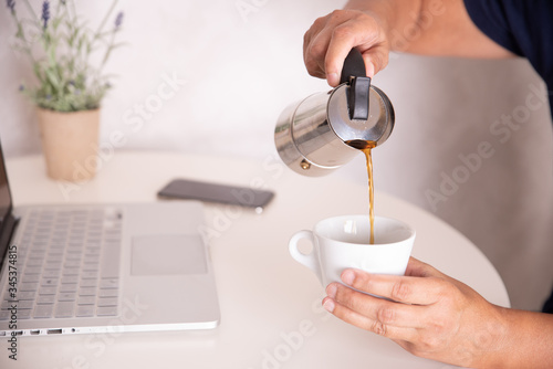 mano sirviendo café con el ordenador