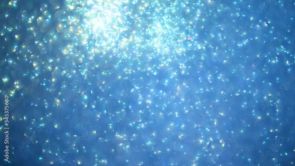 Blue glitter background with sparkling texture. Blue shimmering light. Blue glitter background with sparkling texture. Blue shimmering light.