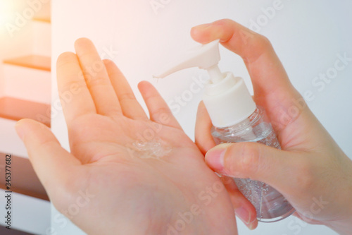Woman hands using gel alcohol sanitizer cleaning her hands, to prevent the virus and bacterias, she protects herself and her family from viruses and bacterias. Hygiene concept.Close up.