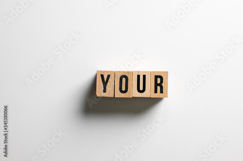 " your " text made of wooden cube on White background.