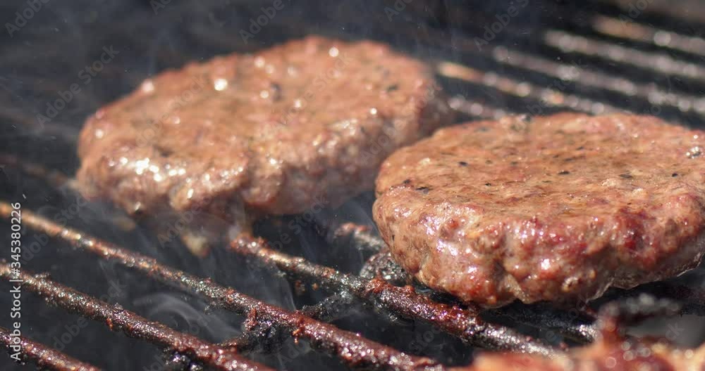 Tasty two hamburger meat frying on smoking hot barbecue. Slow motion video Tasty two hamburger meat frying on smoking hot barbecue. Slow motion video