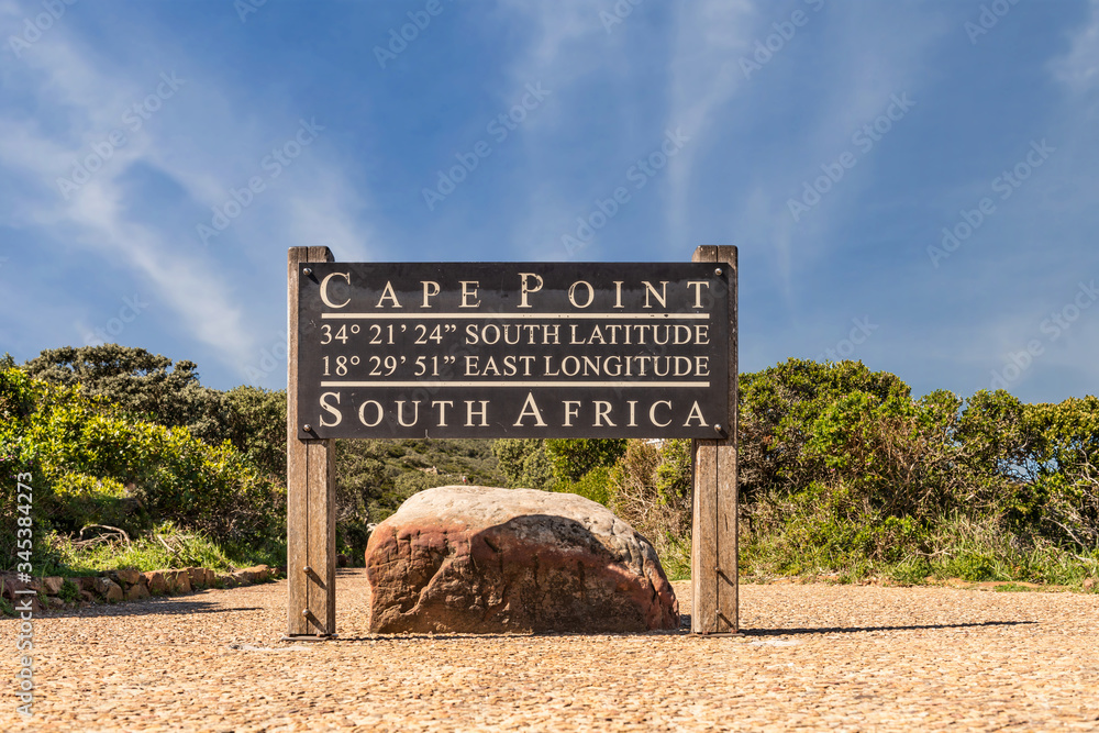 Fototapeta premium Cape Point sign with coordinates next to the lighthouse path with stunning clouds