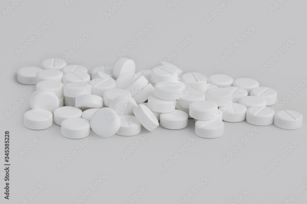 white pills on a white background, a jar of pills