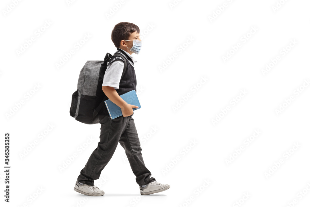 Schoolboy with a backpack walking and wearing a protective face mask Schoolboy with a backpack walking and wearing a protective face mask