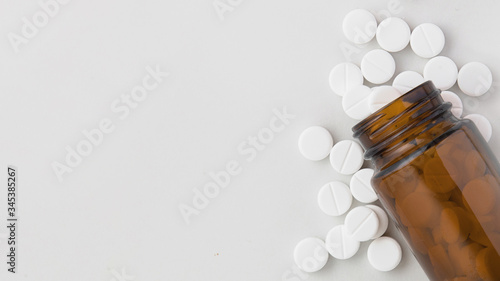 white pills on a white background, a jar of pills