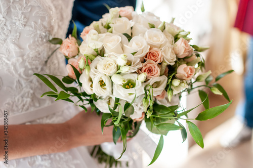 White bouquet of roses in the hand of bride