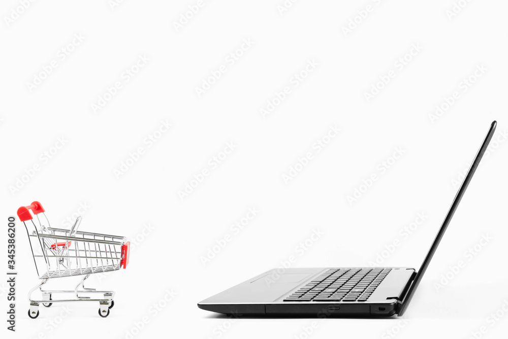 the laptop  and red shopping cart isolated on white background with copy space