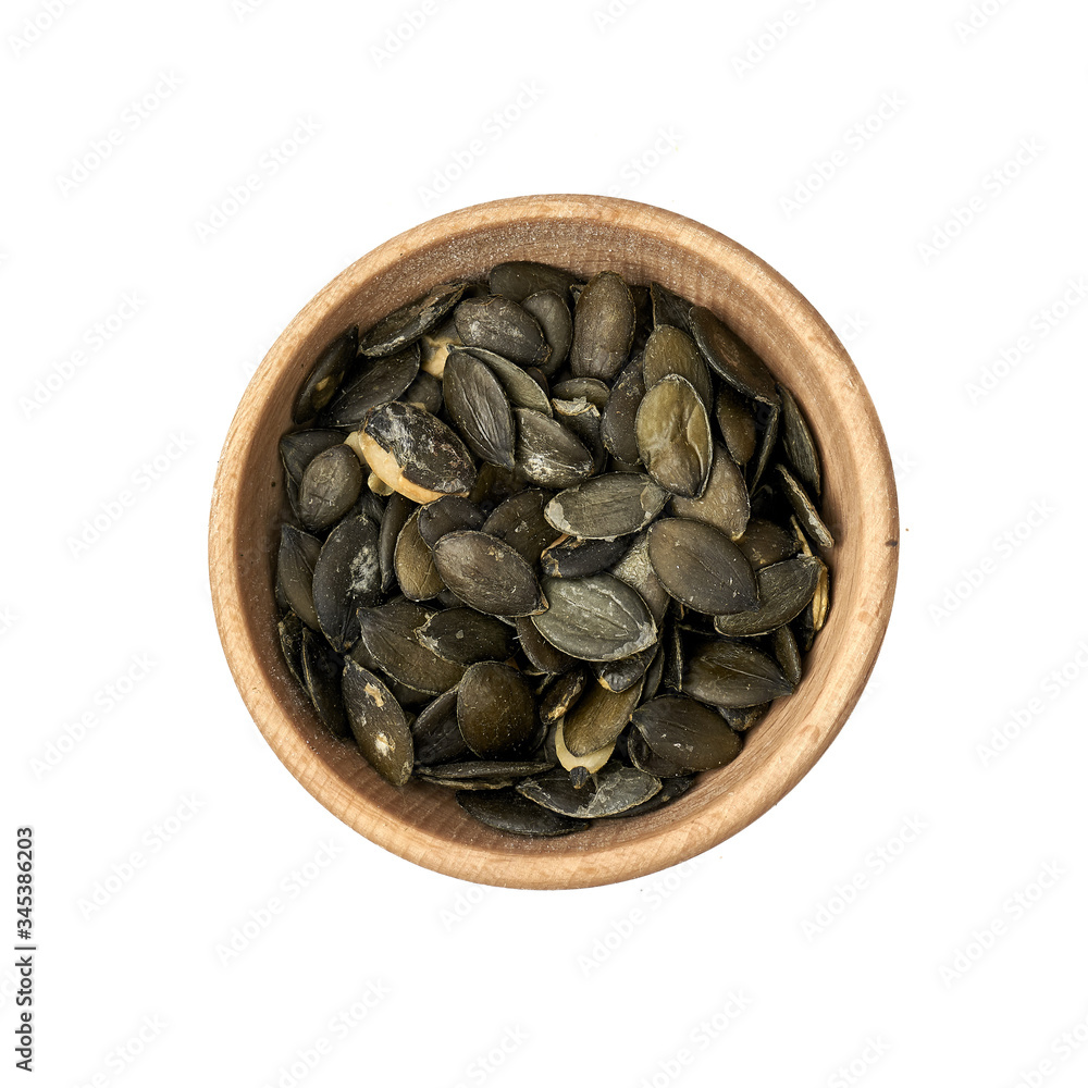 Ziarna dyni w małej miseczce z drewna na białym tle